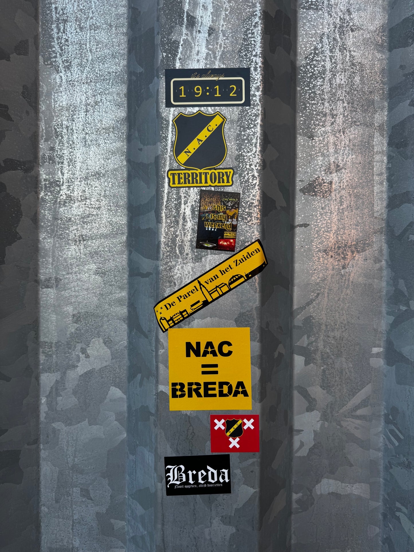 Selectie NAC Breda stickers uit pakket 2, met ontwerpen als NAC = Breda, De Parel van het Zuiden en het clublogo, bevestigd op de stalen hekwerken die de supportersomloop rond het NAC stadion sieren.