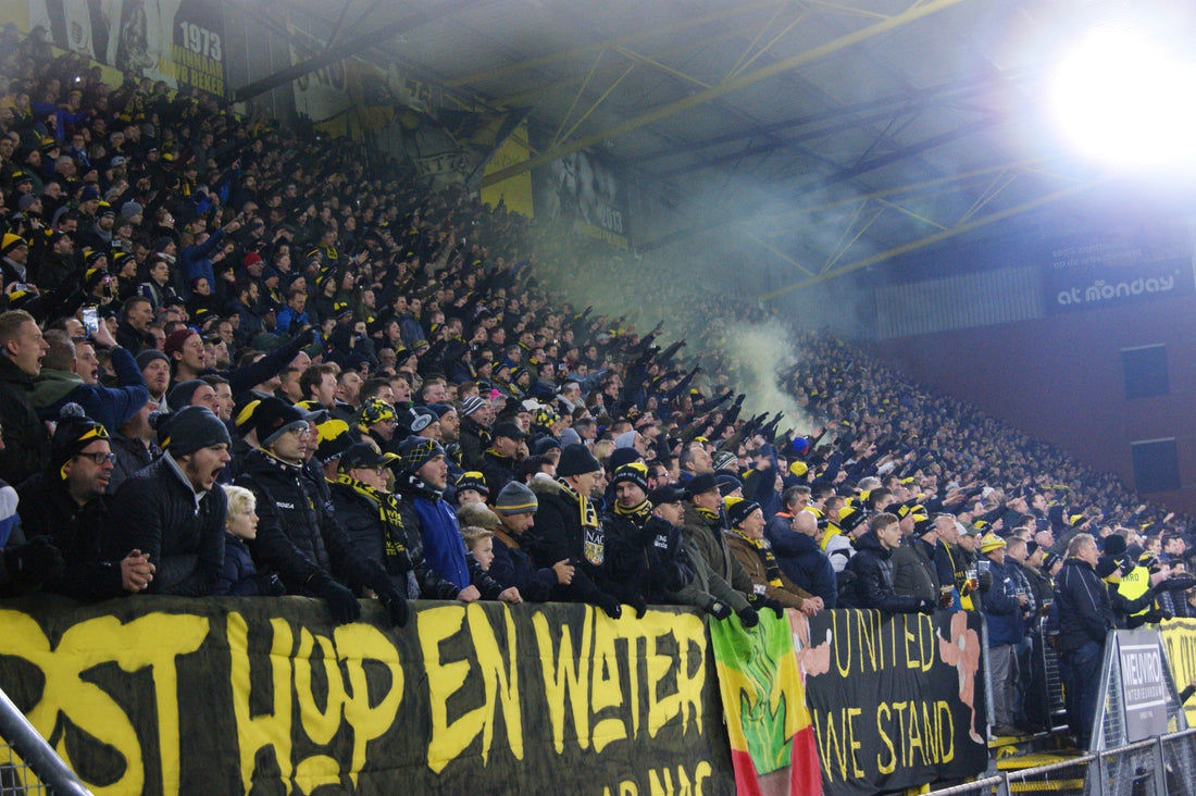 NAC Breda supporters op de tribune in het Rat Verlegh Stadion tijdens een avondwedstrijd