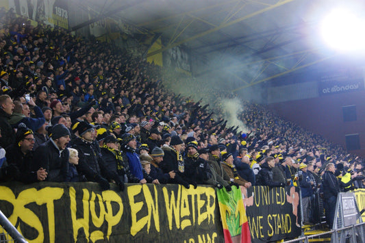 NAC Breda supporters op de tribune in het Rat Verlegh Stadion tijdens een avondwedstrijd