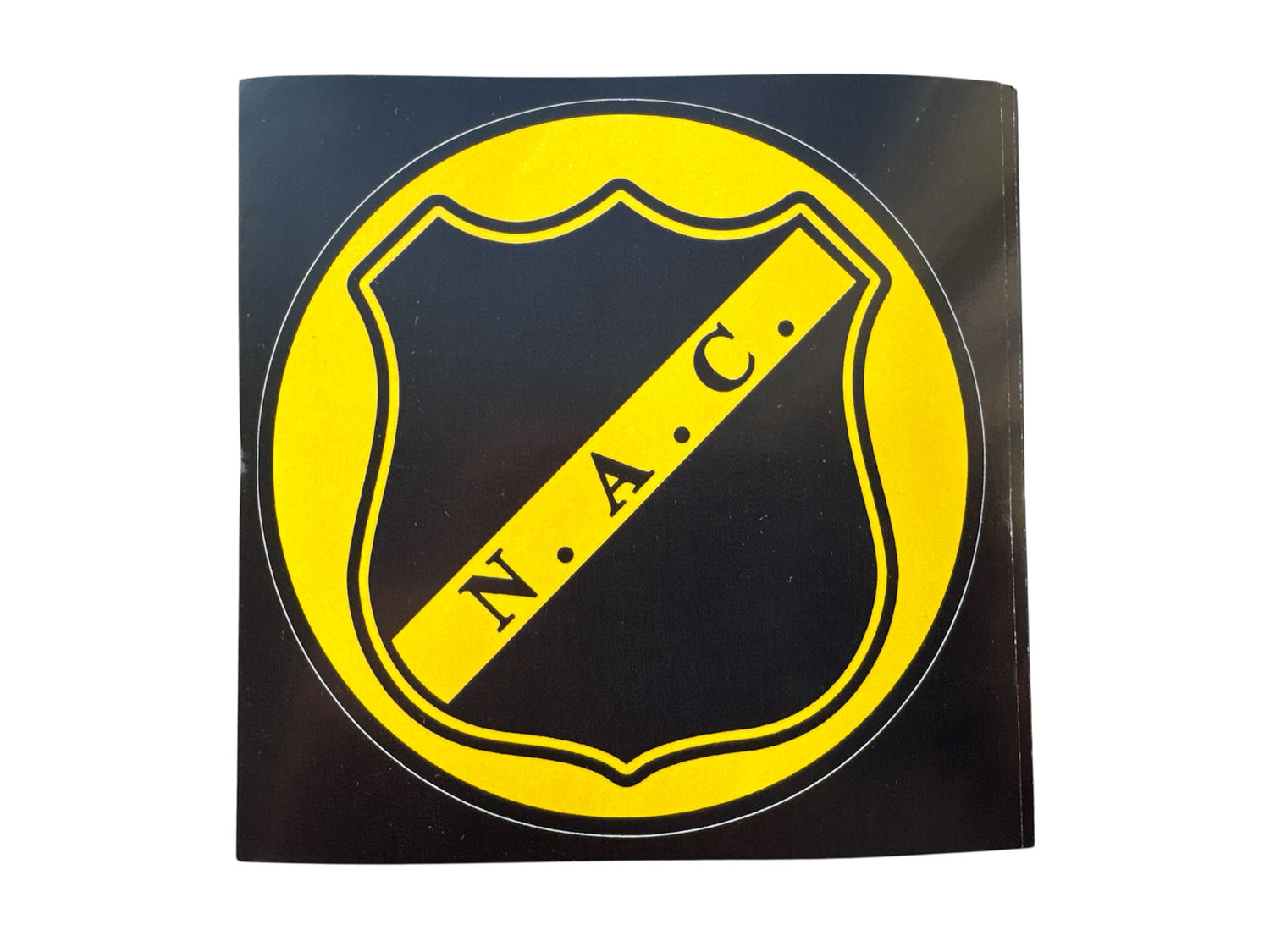 Ronde NAC Breda sticker met het clublogo in geel op een zwart schild, omringd door een gele rand.