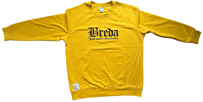 Vooraanzicht van een gele NAC Breda sweater met lange mouwen, zwarte 'Breda' opdruk op de borst en een klein wit 'Code Geel' label aan de onderzijde.